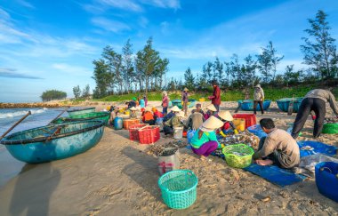 Phan Thiet, Vietnam - 12 Temmuz 2020: Deniz ürünleri pazarı oturumu denizleri, insanlar yengeçlerin, salyangozların ve balıkların içinde toplanıyor, kürek çeken balıkçı balıkları Phan Thiet, Vietnam 'daki balıkçı köyüne getirildi.