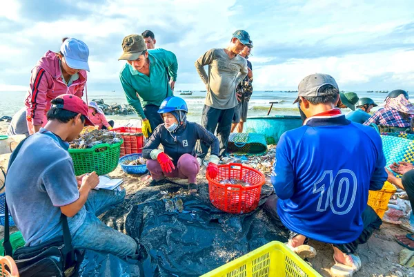 Phan Thiet, Vietnam - 12 Temmuz 2020: Deniz ürünleri pazarı oturumu denizleri, insanlar yengeçlerin, salyangozların ve balıkların içinde toplanıyor, kürek çeken balıkçı balıkları Phan Thiet, Vietnam 'daki balıkçı köyüne getirildi.