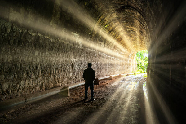 Silhouette traveler man explored in the ancient railway tunnel, abandoned 19th century architecture to today near Da Lat, Vietnam