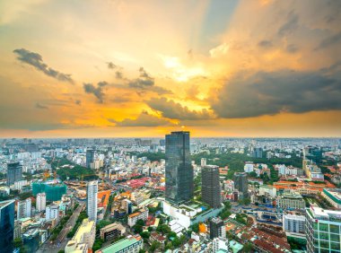 Ho Chi Minh Şehri, Vietnam - 19 Temmuz 2020: Güneş, Vietnam 'ın Ho Chi Minh kentindeki yol gösterici gelişim ülkesi boyunca yüksek binalarla kentsel alanları aydınlattığında yüksek görünüm Saigon silueti
