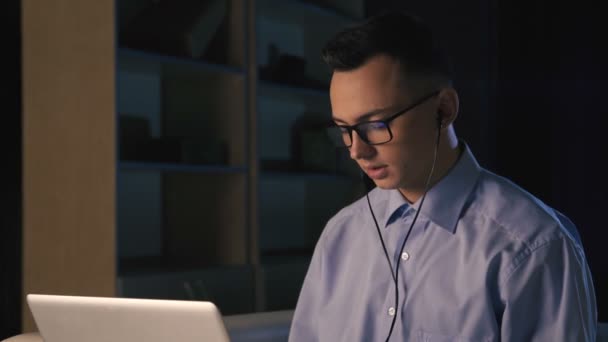 A young man talking on facetime, video chat, dark background — Stock Video