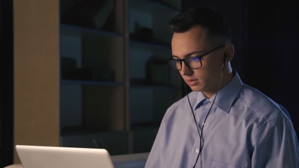 En ung man som pratar på facetime, videochatt, mörk bakgrund — Stockvideo