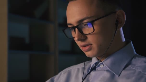 Een jonge man praten op facetime, video chat, donkere achtergrond, close-up — Stockvideo