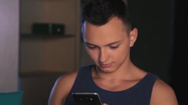 Genç bir adam duygusal bir mesaj bir smartphone, karanlık bir arka plan bir Avrupa yazıyor.