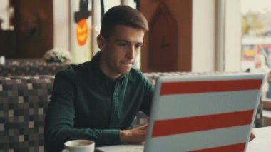 Sakallı adam serbest çok mutlu ve kafede dizüstü bilgisayar önünde oturan sevinir