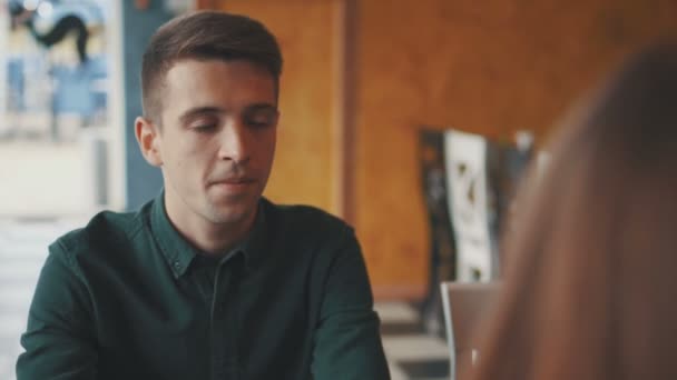 Дівчина і чоловік розмовляють у міському кафе — стокове відео