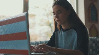 Bir kafede bir dizüstü bilgisayar ile çalışan serbest meslek sahibi kadın kapatmak görünümü