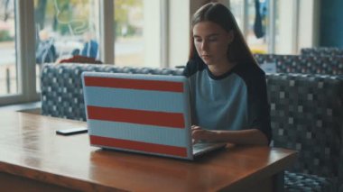 Bir kafede genç, güzel kız, kahve içme, gülümseyen ve bir bilgisayar ile telefonda konuşurken.