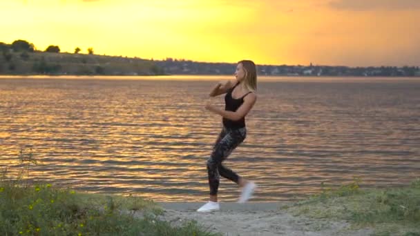 Jonge vrouw in Romper beoefenen van yoga op het strand boven zee bij verbazingwekkende zonsopgang — Stockvideo