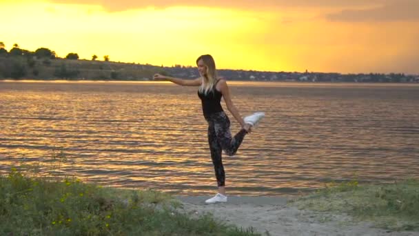 Jonge vrouw in Romper beoefenen van yoga op het strand boven zee bij verbazingwekkende zonsopgang — Stockvideo