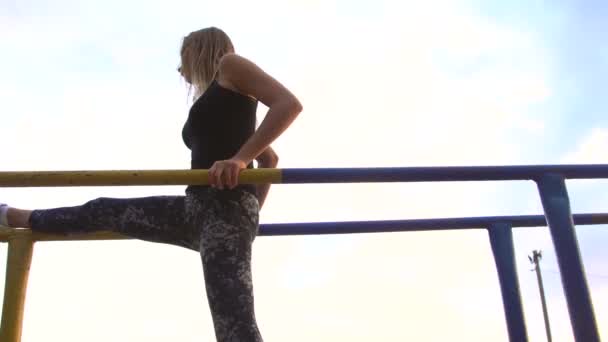 Молодая женщина в боди-костюме практикует йогу — стоковое видео