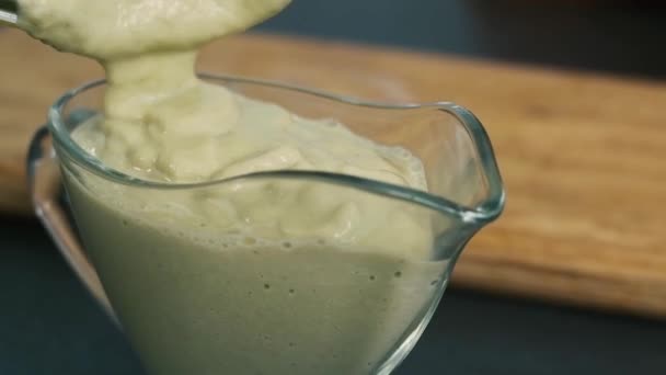 Cocinar un postre delicioso y saludable. mezcla de plátano, menta, leche. comida mezclada en una licuadora. Primer plano de la comida. Dulce desayuno. comida saludable. Vierta la crema en el plato . — Vídeos de Stock