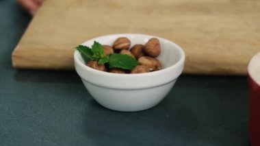 Fındık çekirdeği kabuğunun üzerinde soyulmuş. Kırmızı kasede ev yapımı sağlıklı bir tatlı.