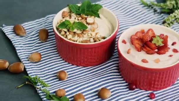 健康的なデザートが飾られた2つのボウルの上からの眺め新鮮なイチゴとヘーゼルナッツ。朝食と健康的なライフスタイルの概念 ストック映像