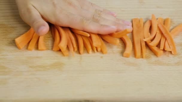 Gătit acasă. Aproape de dungi lungi sau felii de morcovi create prin tăierea morcovului. Dungi lungi sau felii de morcovi pe placa de tăiere . — Videoclip de stoc