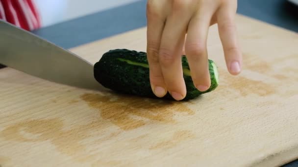 Kesme tahtasındaki bir bıçakla salatalık kesmek. Bir kadın bıçakla salatalık kesiyor. Telifsiz Stok Video