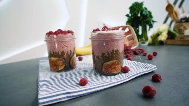 Smoothie-Glas dekoriert mit Kokos und Himbeeren. Serviert Glas mit gesunden Smoothie mit Haxen, Himbeeren, Bananen und Kokosnüssen. Seitenansicht. — Stockvideo