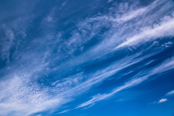 Blue sky with white abstract spindrift clouds