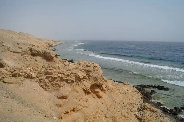 Mar vermelho azul bonito com ondas e rochas e céu azul claro no Egito — Fotografia de Stock
