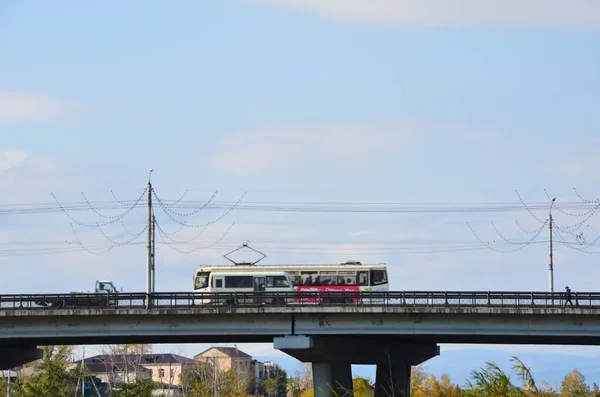 这幅画显示了一辆电车 它与一座桥上的公交车搭在乌兰乌德城 Selenga — 图库照片