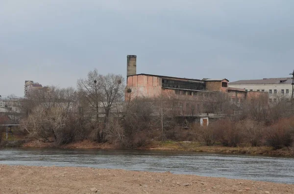 这张图显示的是一座具有河前景的老厂房 — 图库照片