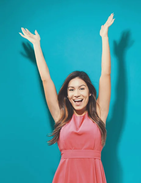 Happy young woman raising her arms