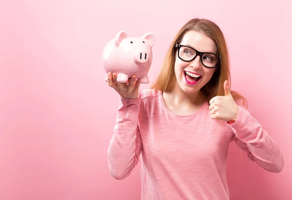 Jovem com um banco porquinho — Fotografia de Stock