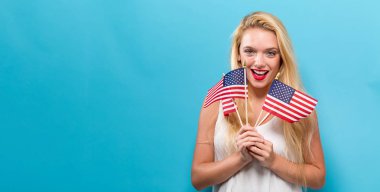 Bir Amerikan bayrağı tutan mutlu genç kadın