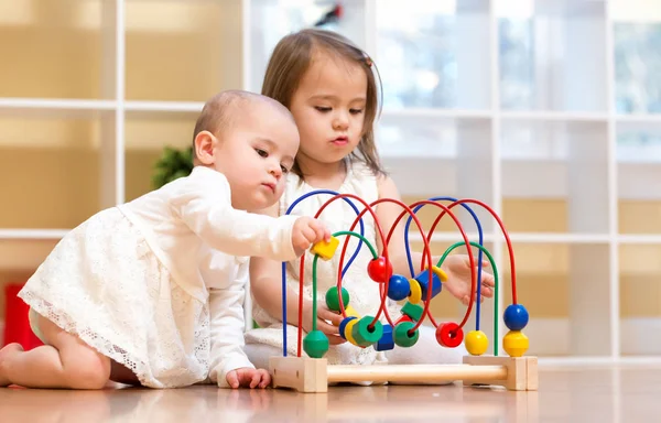 Yürümeye başlayan çocuk kız oyuncakları ile birlikte oynarken — Stok fotoğraf