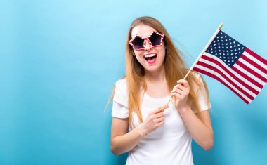 Bir Amerikan bayrağı tutan mutlu genç kadın