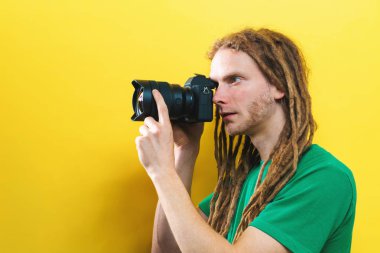 Genç adam profesyonel bir kamera tutarak