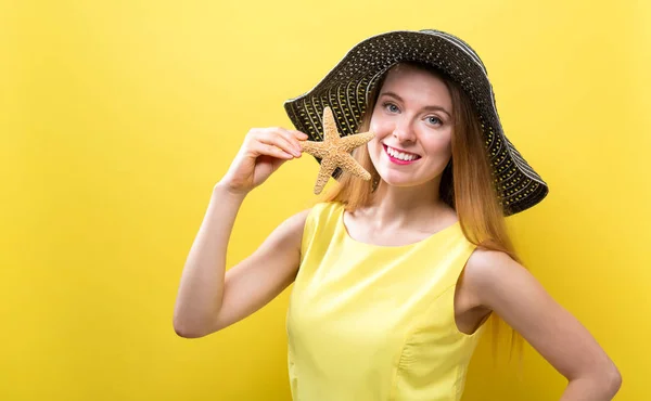 Happy young woman holding a starfish — Stock Photo, Image