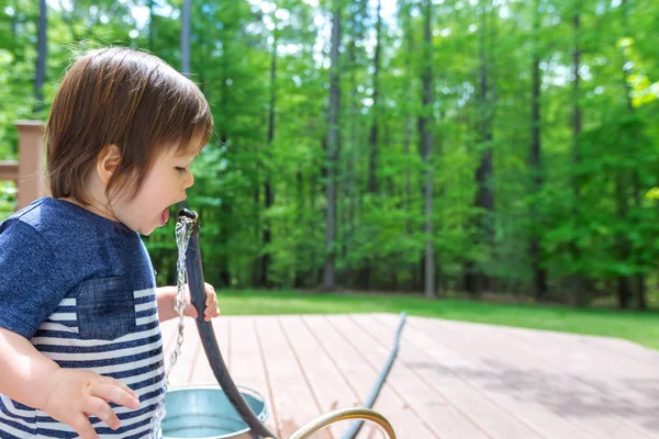 水と遊ぶ若い幼児の少年 — ストック写真