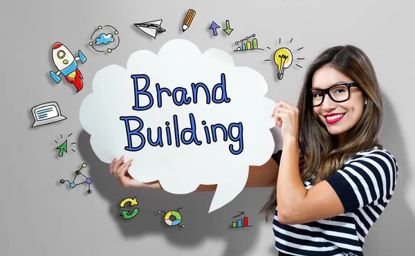 Brand Building testo con donna in possesso di una bolla discorso — Foto Stock