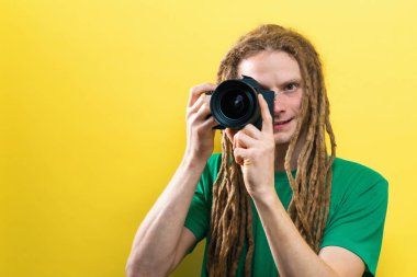 Genç adam profesyonel bir kamera tutarak