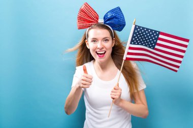 Bir Amerikan bayrağı tutan mutlu genç kadın