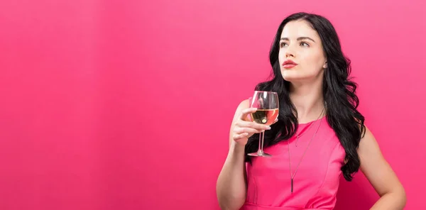 Młoda kobieta, picie wina na jednolitym tle — Zdjęcie stockowe