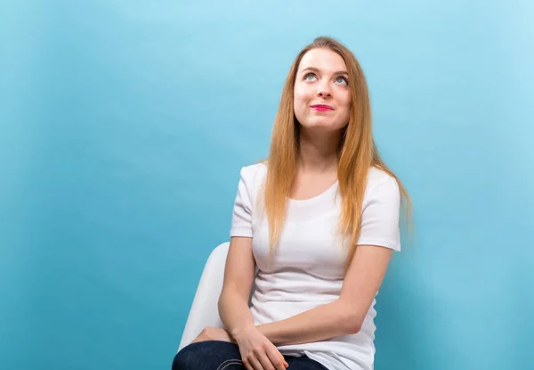 Portret van een jonge vrouw zittend in een stoel — Stockfoto