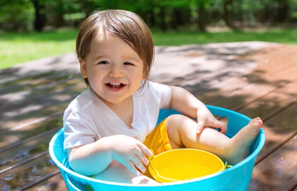 Jonge peuter jongen spelen met water — Stockfoto