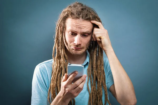 Un joven mirando su celular — Foto de Stock