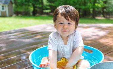 Su ile oynamak genç yürümeye başlayan çocuk