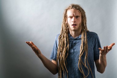 Karanlık bir arka plan üzerinde shrugging genç adam