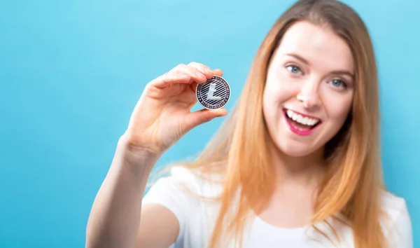 Vrouw met een fysieke Litecoin — Stockfoto