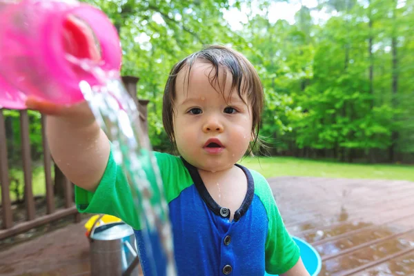 Jonge peuter jongen spelen met water — Stockfoto