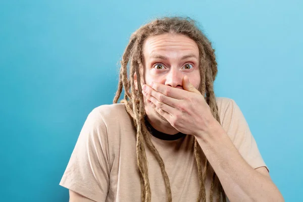 Muž pokrývající ústa na pevné pozadí — Stock fotografie