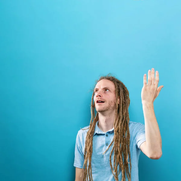 Joven alcanzando y mirando hacia arriba — Foto de Stock