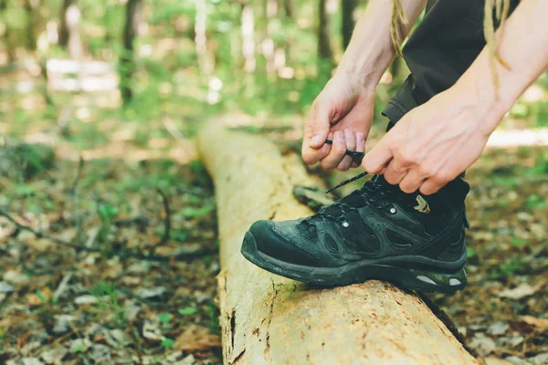 Wandelaar koppelverkoop boot veters op een log — Stockfoto