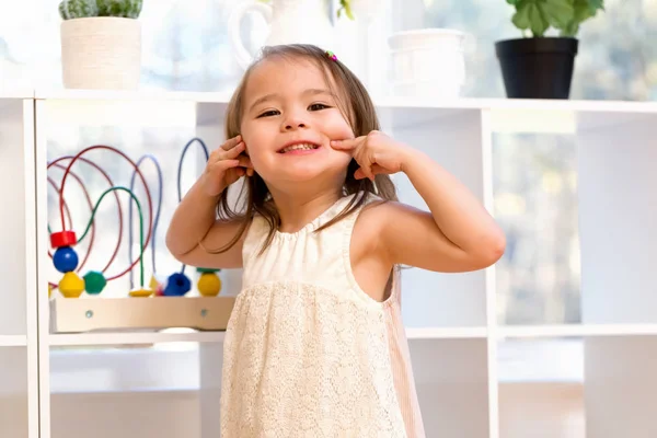 Ευχαρίστως toddler κορίτσι κάνοντας μια αστεία γκριμάτσα — Φωτογραφία Αρχείου
