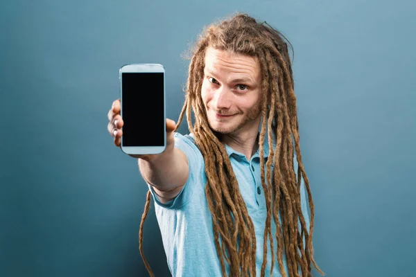 Joven sosteniendo un celular — Foto de Stock