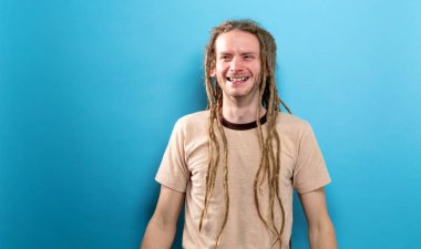 Mutlu genç adam sağlam bir arka plan üzerinde